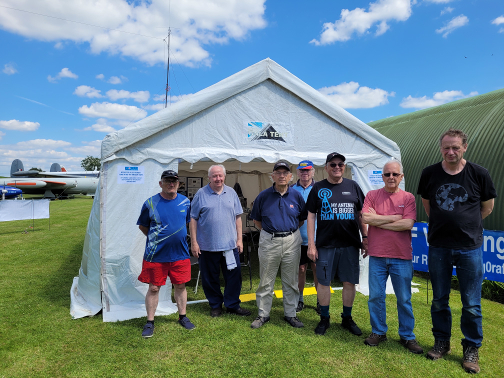 The G B 0 N A M setup team pose in front of the operating tent